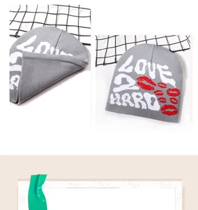 Primer plano de gorro gris con texto LOVE 2 HARD blanco y estampados de labios rojos