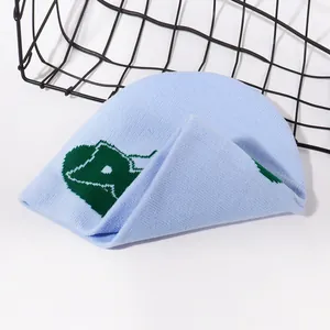 Close-up of light blue knit beanie with green jacquard pattern on a metal basket