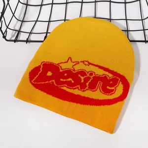 Detailed knit texture of bright yellow beanie with red Desire lettering embroidery