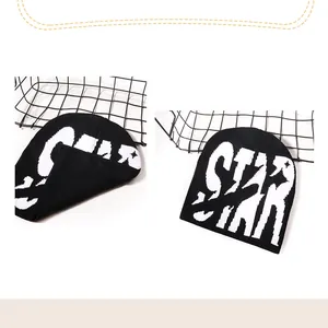 Gros plan détaillé sur la texture tricotée et le lettrage STAR de ce bonnet noir streetwear