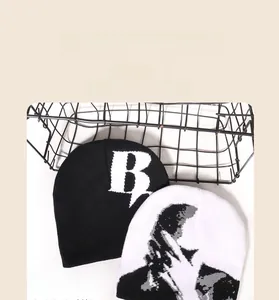 Détail du tricot de bonnets d'automne-hiver avec lettre B et motifs de silhouettes d'art