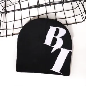 Bonnet en tricot noir avec motif jacquard B7 blanc contrasté sur fond blanc épuré