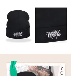 Nahaufnahme der dichten weißen Stickerei auf einer schwarzen Strickmütze mit Umschlag