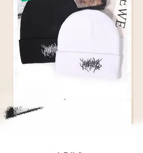 Nahaufnahme der schwarz-weißen Strickmützen mit Gothic-Stickerei auf dickem Stoff