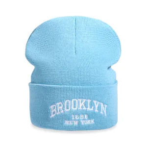 Light blue knit beanie with Brooklyn 1898 embroidery on a white background