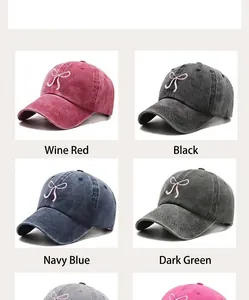 Close-up of bow embroidery details on vintage washed denim baseball caps in four colors