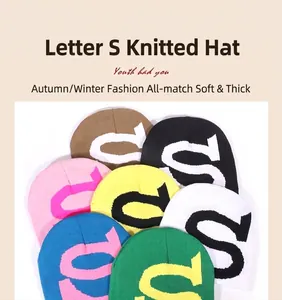 Detailaufnahme bunter Strickmützen mit großem S-Buchstaben in verschiedenen Winterfarben