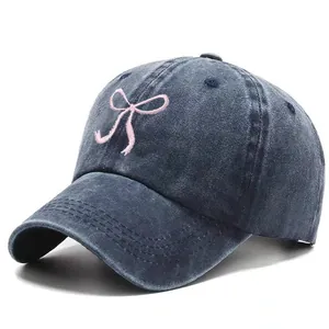 Vintage washed denim baseball cap with pink bow embroidery on charcoal gray fabric