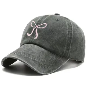 Washed dark gray denim baseball cap featuring pink bow embroidery and soft top design