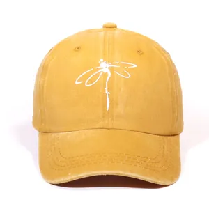 Front view of washed ginger baseball cap with a minimalist white dragonfly embroidery