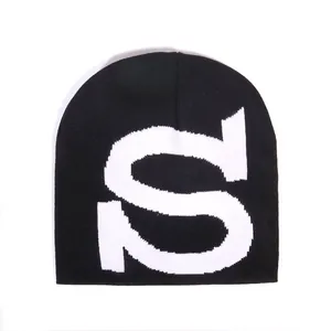 Schwarze Strickmütze mit auffälligem weißem eingewebtem S-Buchstaben in minimalistischem Stil