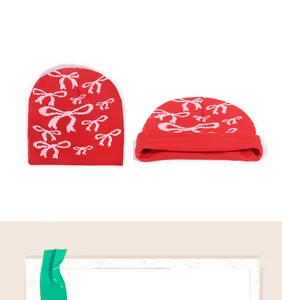 Détail du bonnet en maille rouge avec motifs nœuds roses et texture de fil de qualité