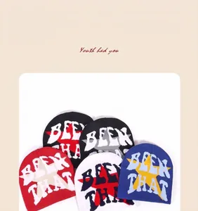 Detail showing thick knitted texture and bold lettering on street style beanies