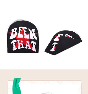 Close-up of knit beanie featuring white BEEN THAT lettering and red star graphics