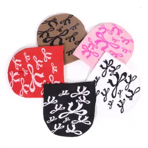 Ensemble de cinq bonnets tricotés à motifs de nœuds en marron, rose, rouge, noir et blanc