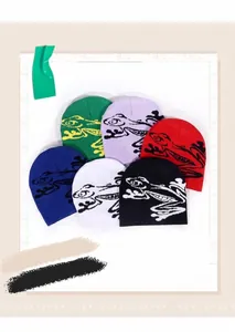 Detail of six colorful knitted beanies with various cartoon frog patterns and soft textures