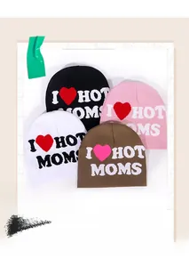 Macro view of four knitted beanies in black, pink, white, and brown with jacquard text