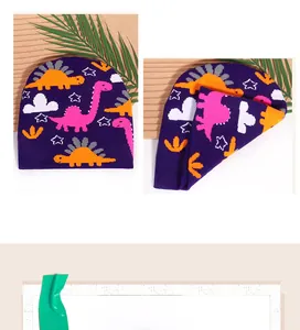 Detailed knit texture of purple dinosaur beanie with soft cartoon jacquard patterns