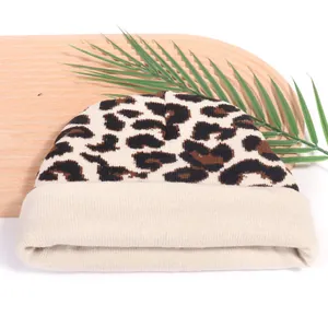 Chic leopard print knitted beanie in cream and brown on a natural wooden display background