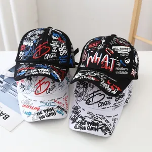 Close-up of black and white baseball caps featuring street graffiti print and slogans