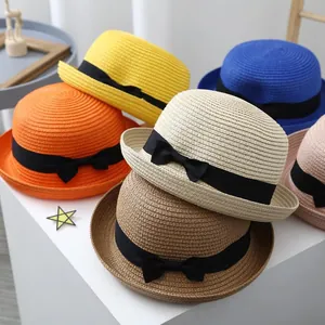 Detailed view of colorful woven straw hats with black ribbons for kids summer sun protection