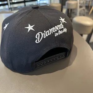 Détail de la casquette snapback noire avec étoiles brodées et texte Diamond in the sky