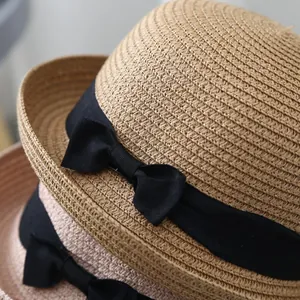 Close-up of woven straw texture and decorative black ribbon bow on summer beach hats