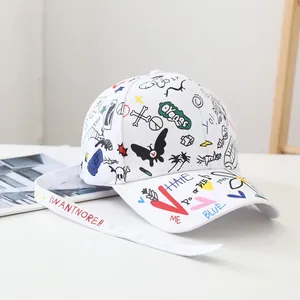 Detail of white graffiti baseball cap featuring street art prints and long strap