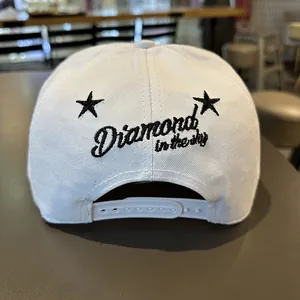 Détail d'une casquette snapback blanche avec broderie noire au dos du chapeau