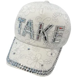 White lace baseball cap featuring TAKE rhinestone letters and diamond-studded brim