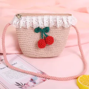 Close-up of pink straw bag with white lace trim and handmade crochet cherry charm