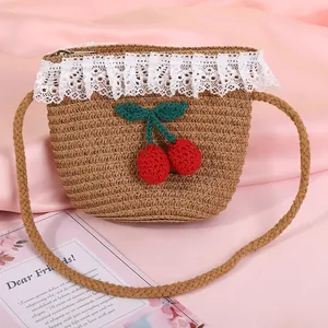 Kids straw crossbody bag with lace trim and crochet cherry charms on pink silk
