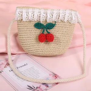 Fashionable straw shoulder bag for kids with lace trim and cherry decor on pink fabric