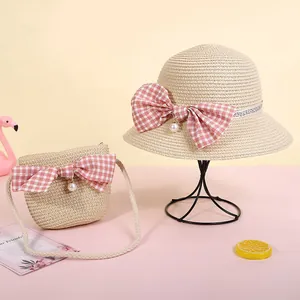 Details von Strohhut und Tasche mit rosa Karo-Schleife und Perlenanhängern für Kinder