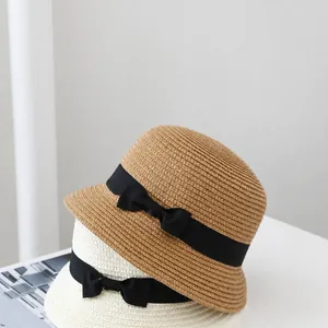 Detailed view of woven straw cloche hats featuring elegant black ribbons and bows