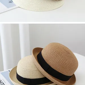 Detail of straw hat weave and black ribbon in white, beige, and khaki colors