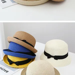 Detailed weave pattern of straw sun hats in multiple colors with elegant black ribbon bows