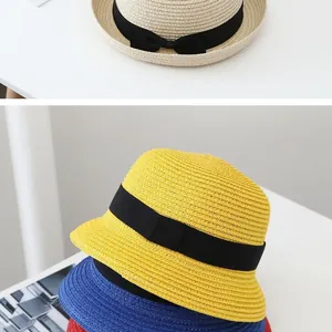 Detailed close-up of woven straw sun hats with black decorative ribbons and bows