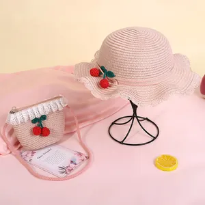 Pink straw sun hat for kids with cherry crochet decor and matching mini lace shoulder bag