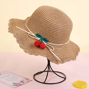 Detail of straw hat with knit cherry decoration and wavy lotus leaf edges