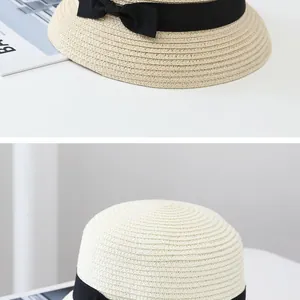 Detail of hand-woven straw texture and black satin ribbon bow on a summer sun hat
