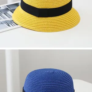Detail of hand-woven straw sun hat texture with black grosgrain ribbon bow decoration