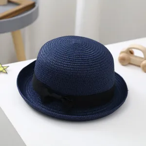 Classic navy blue children's dome straw hat with a black ribbon bow for summer sun protection