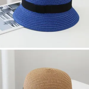 Detailed view of woven straw sun hats with black decorative ribbons in blue and natural tan
