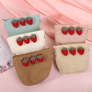Detail der farbenfrohen Mini-Strohtaschen mit Erdbeer-Patches und Metallreißverschluss