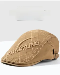 Détail d'un béret kaki avec surpiqûres en losanges et broderie lettrée BUSTLING élégante