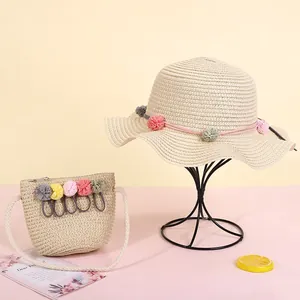 Detalle de set de sombrero de paja y bolso con pompones de colores para niños
