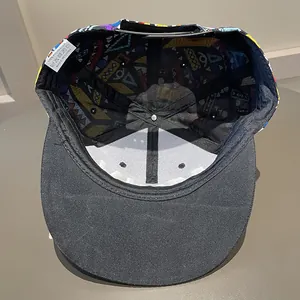 Detail view of the black snapback cap with 100% polyester fabric and colorful printed lining
