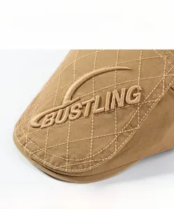 Détail de la casquette plate kaki avec surpiqûres en losanges et broderie bustling
