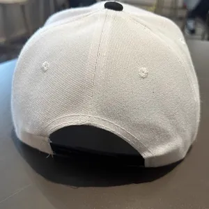 Vue détaillée de la casquette blanche avec fermeture réglable en plastique noir et coutures